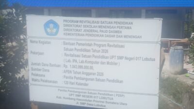 Papan informasi proyek revitalisasi di UPT SMP Negeri 017 Lobutua, Kabupaten Humbang Hasundutan. Proyek senilai Rp1.043.999.000 yang bersumber dari APBN Tahun Anggaran 2026 itu dikerjakan selama 120 hari kalender oleh Panitia Pembangunan Satuan Pendidikan. Foto: http://Instrumentasi.com