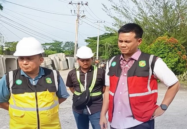 Kepala Dinas SDABMBK Kota Medan Khairul Azmi meninjau pemasangan saluran U-Ditch di Jalan Abdul Hakim, Kecamatan Medan Selayang, Kamis 27 Agustus 2026. Progres pekerjaan saat ini telah mencapai 50 persen. Foto: