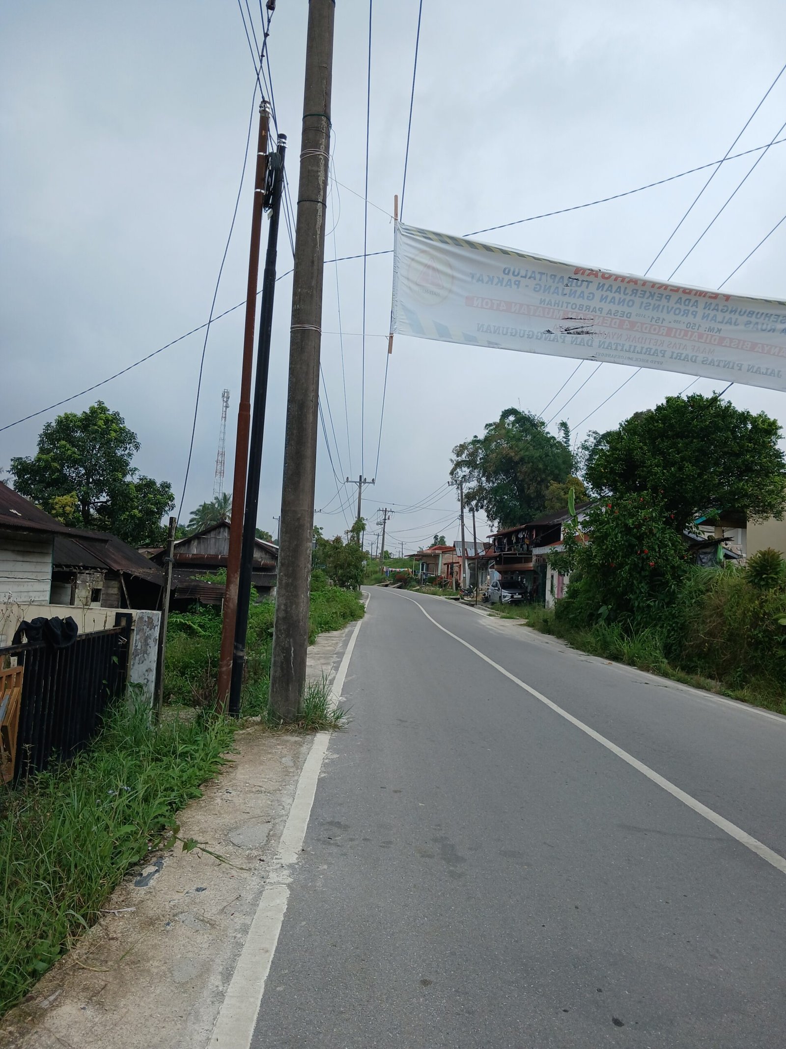 Kondisi tiang jaringan WiFi yang dipasang tidak sesuai standar umum di tepi jalan provinsi, tampak berdiri mepet marka jalan dan berdempetan dengan tiang lain, rawan bahayakan pengguna jalan.