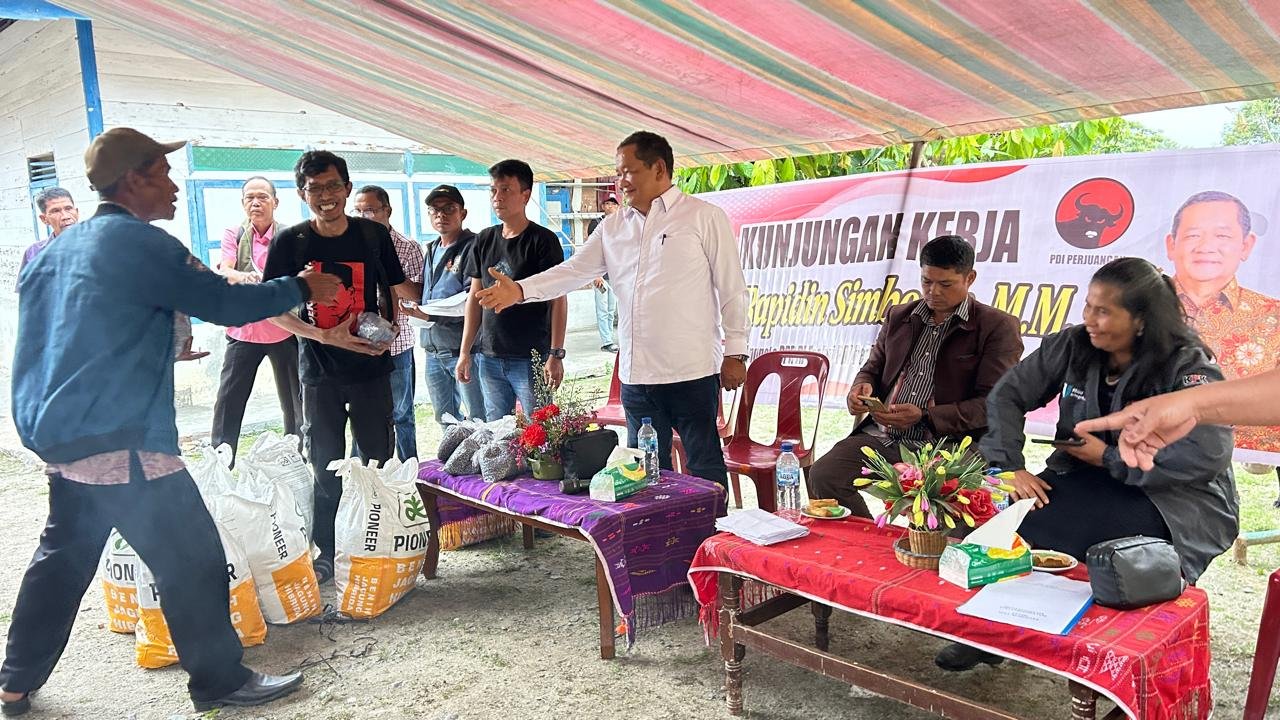 Anggota DPR RI Komisi XIII Drs. Rapidin Simbolon, MM menyerahkan bantuan benih jagung Pioneer 32 kepada petani di Desa Suhutnihuta Pardomuan dan Desa Parsaoran Urat, Kabupaten Samosir, Jumat (2/10/2026).