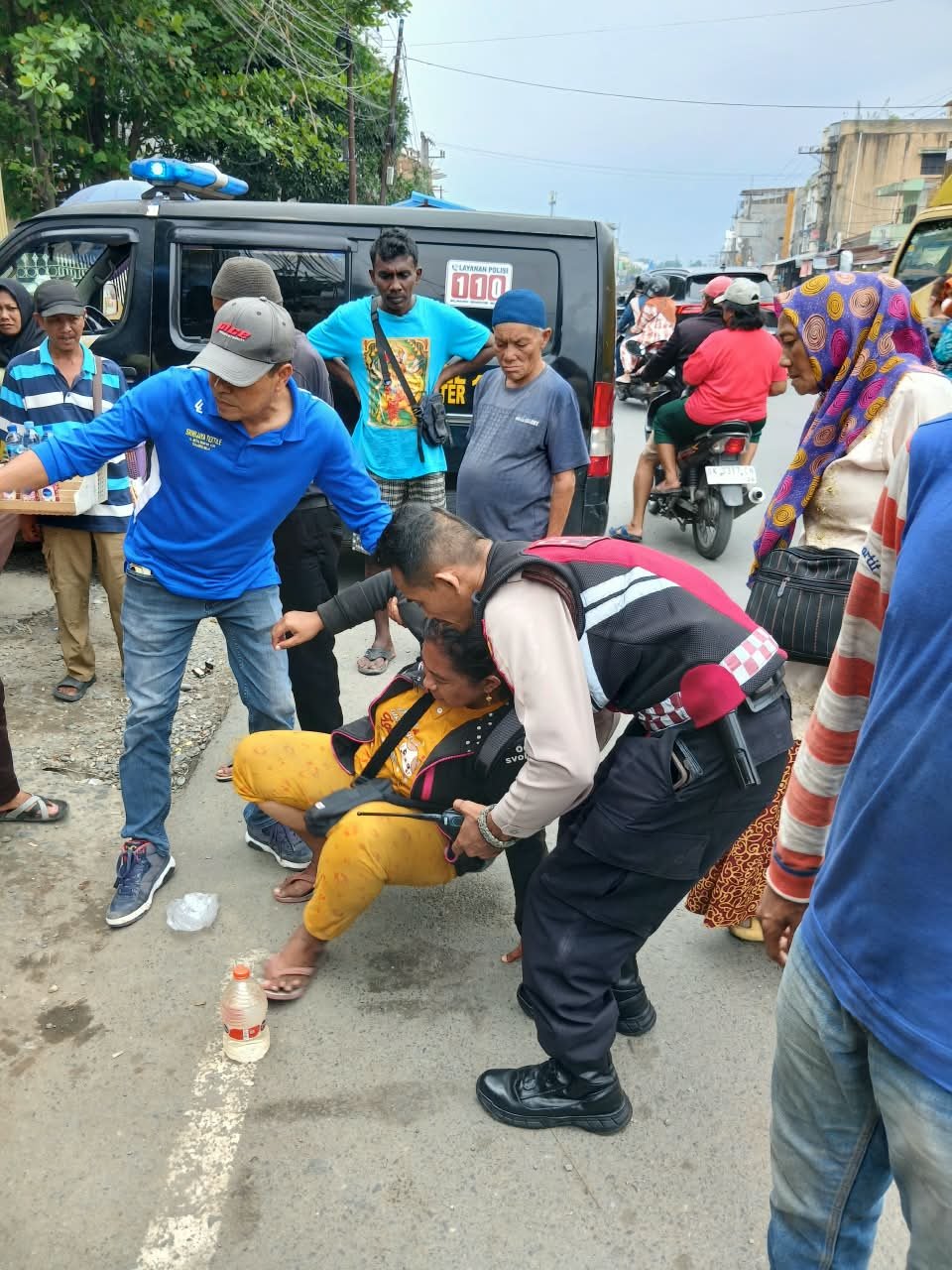 Personel Sat Samapta Polsek Sunggal memberikan pertolongan kepada wanita yang ditemukan tergeletak di pinggir jalan depan Masjid Jamik, Kelurahan Lalang, Kamis (8/10/2026).