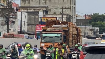 Ditengah Guyuran Hujan, Kapolsek Sunggal Atur Lalin Pagi Hari di Wilayahnya